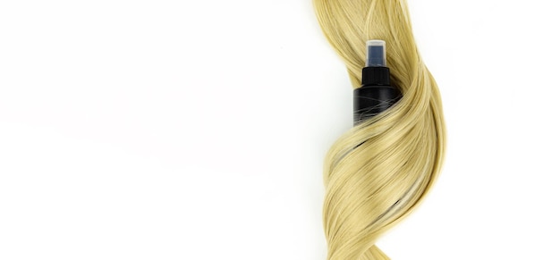 Different professional hairdresser tools hair spray and strand of blonde hair on white background flat lay Accessories for haircut with copy space