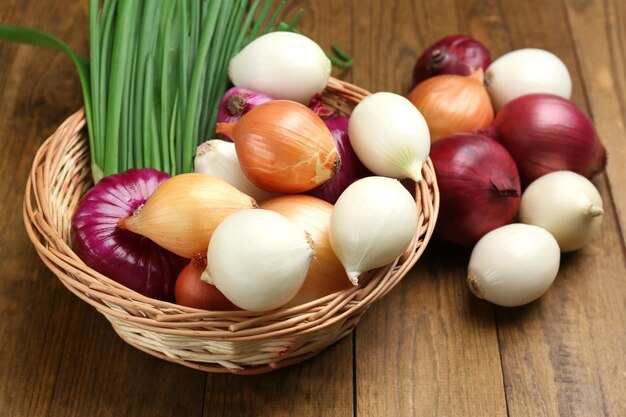 Different raw onion on wooden background