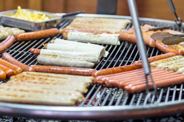 different sausages in pita bread and without pita roast on a grill over the coals