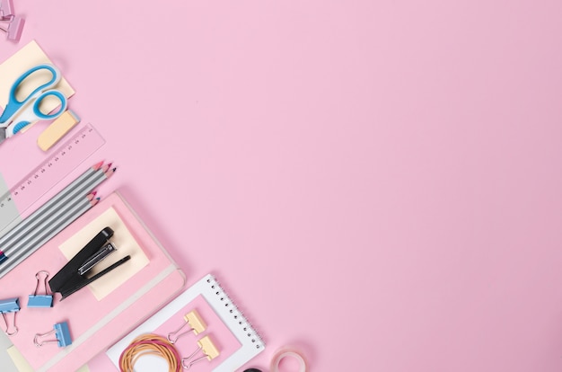 Different school supplies on light pink background