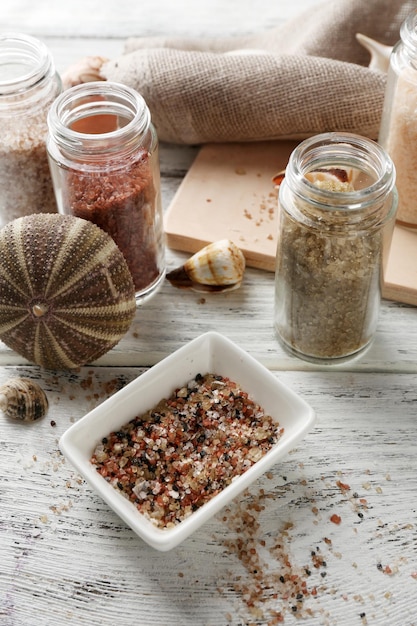 Different sea salt on wooden table close up