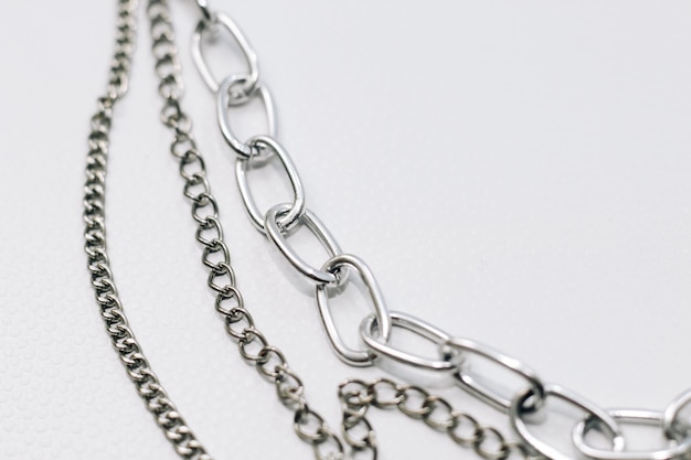 Different silver metal chains on a light background