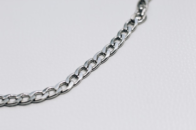 Different silver metal chains on a light background