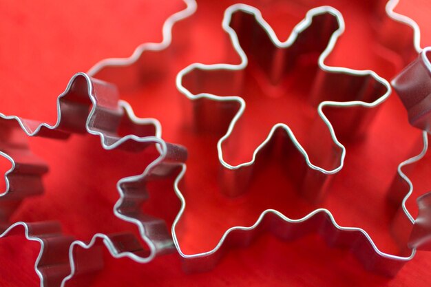 Photo different size metal cookie cutters in shape of snow flakes.