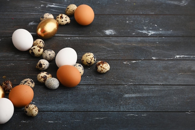 Different size quail and chicken eggs on a wooden surface Horizontal