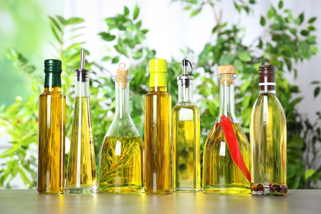 Различные виды растительного масла в бутылках на светло-сером столе