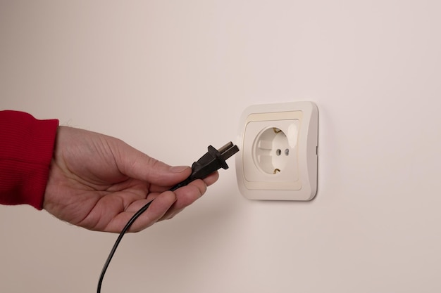 Photo different standards for electrical outlets unsuitable connector and plug in the hand of a person incompatibility concept