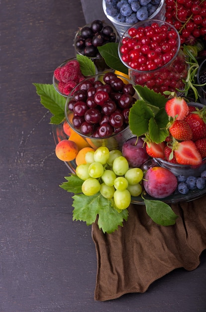 Different summer berries red currant, gooseberry, raspberry in glass trays