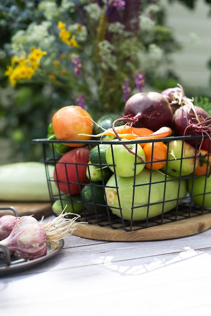 Photo different summer vegetables are in the basket on the tabele outdoor top view