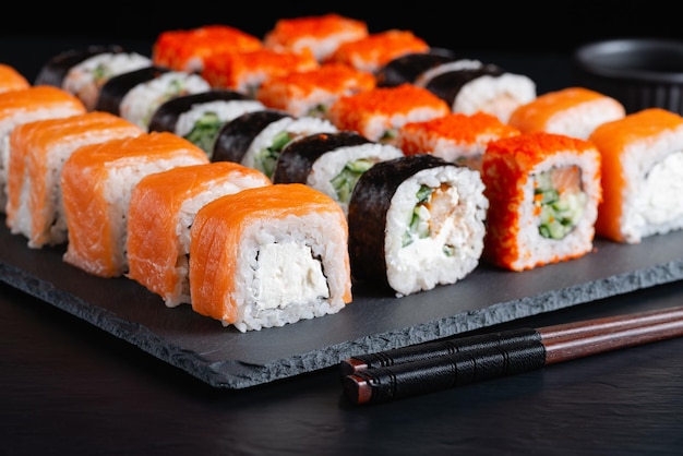 Diversi rotoli di sushi su uno sfondo nero