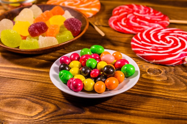 Different sweet candies on rustic wooden table