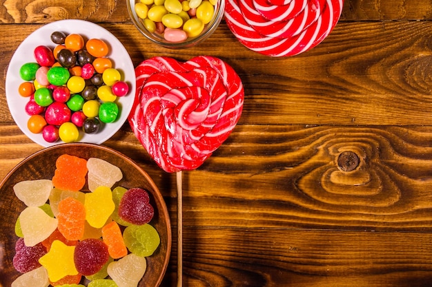 Different sweet candies on a wooden table Top view