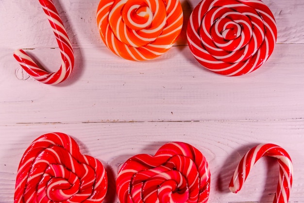 Different sweet lollipops on a wooden table Top view