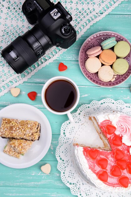 Foto dolci diversi e macchina fotografica sulla vista dal piano del tavolo