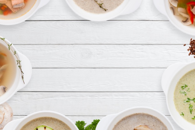 Photo different tasty soups frame on white wooden table