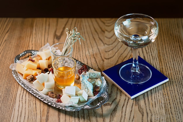 different type of cheese on the tray and cocktail