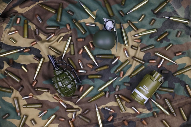 Различные типы боеприпасов и гранат на камуфляжном фоне Подготовка к войне Владение оружием