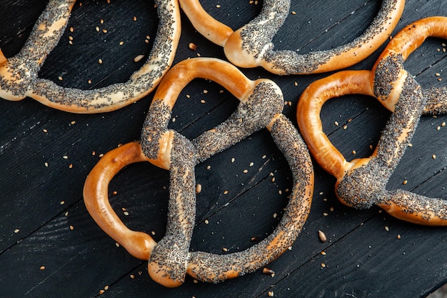 Foto diversi tipi di bagel al forno con semi su sfondo nero