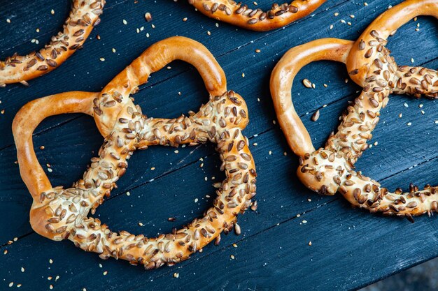 Different types of baked bagels with seeds on a black background