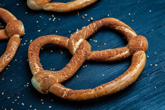 Different types of baked bagels with seeds on a black background