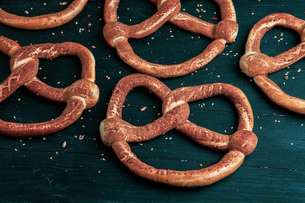 Different types of baked bagels with seeds on a black background