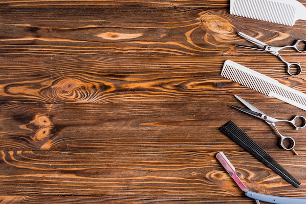 Photo different types of barber tools in a row on wooden surface