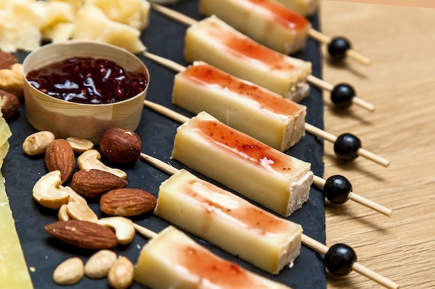 Different types of cheese at a presentation from cheese makers. Top view of a cheese plate with blue cheese, brie with nuts, honey on a wooden table.