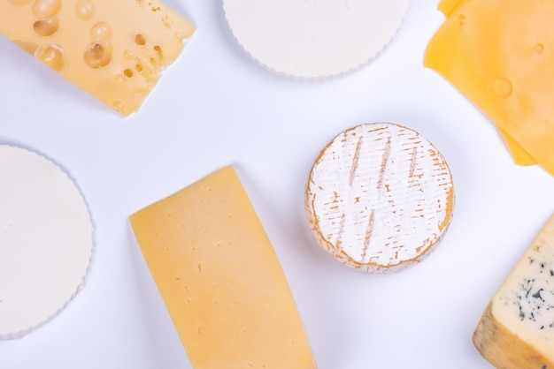Diversi tipi di formaggio su sfondo bianco.
