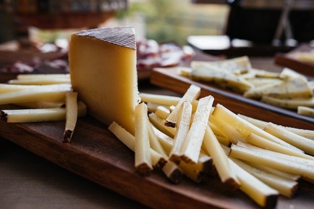 Different types of cheeses on black board.