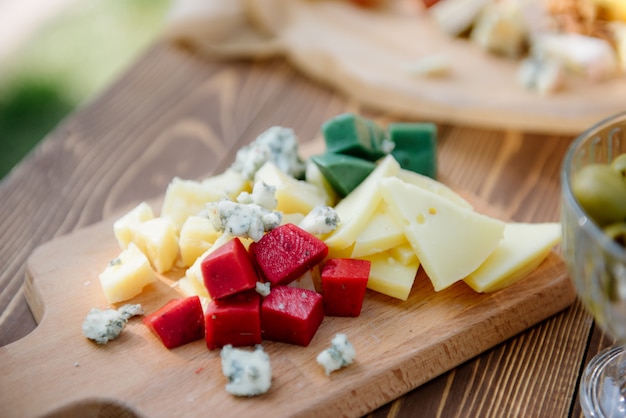 Different types of cheeses on cutting board