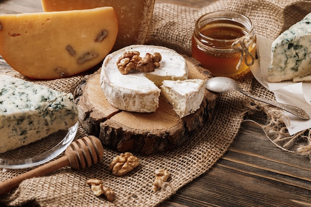 Photo different types of cheeses. slices of cheese brie or camembert with parmesan