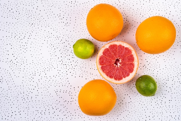 Different types of citrus on dotted background