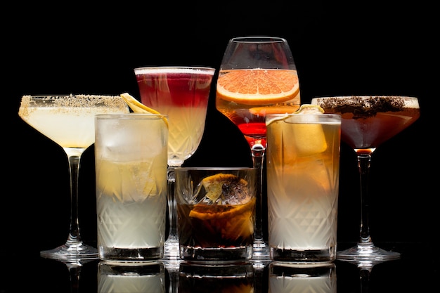 Different types of cocktails are isolated on a black background.