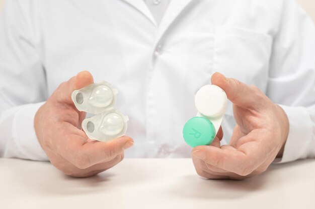 Different types of contact lenses. doctor ophthalmologist holds and comparing one-day contact lenses and reusable contact lenses. cropped view of man choosing ways of vision correction