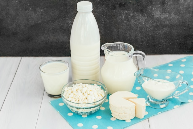 Different types of dairy products on white wooden background.