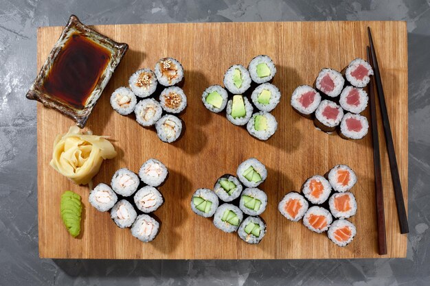 さまざまな種類の美味しくてジューシーな寿司と木の板のロール