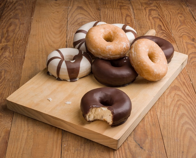 Photo different types of donuts on wooden table