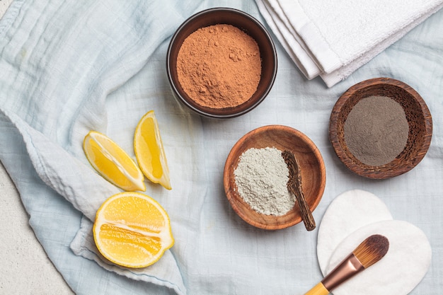 Different types of dry clay in wooden bowls for the preparation of facial masks,