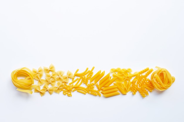 Different types of dry pasta on white.