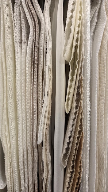Different types of fabrics of different shades hang on hangers in a private workshop