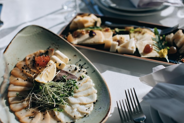 Different types of fish on a plate Wedding table setting with food in restauran