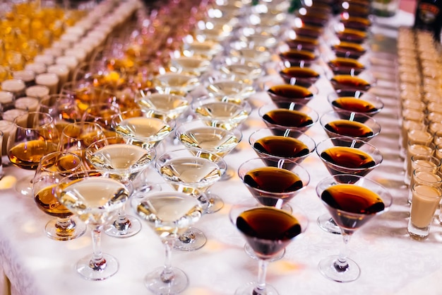 Different types of glasses and alcoholic beverages on the table wedding banquet