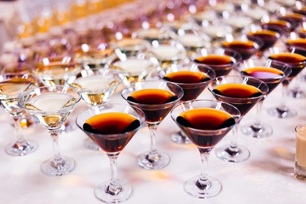 Different types of glasses and alcoholic beverages on the table wedding banquet