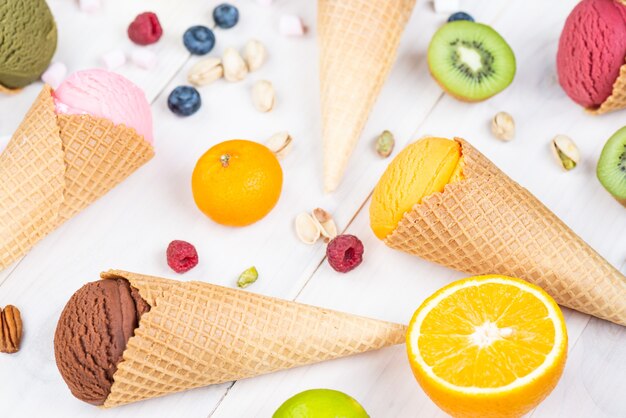 Different types of ice cream with berries and fruits on a wooden table