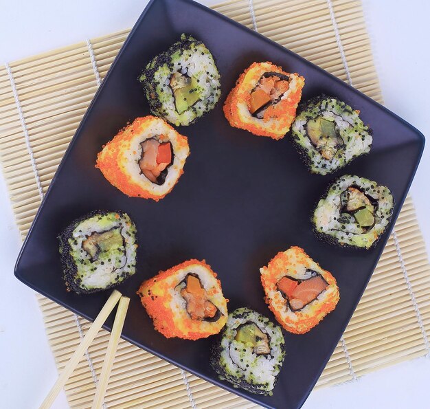 Different types of maki sushi on a black plate