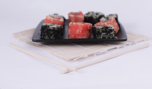 Different types of Maki sushi on a black plate