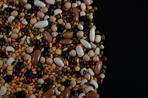 Photo different types of mixed legumes filling the image copy space on the right black background