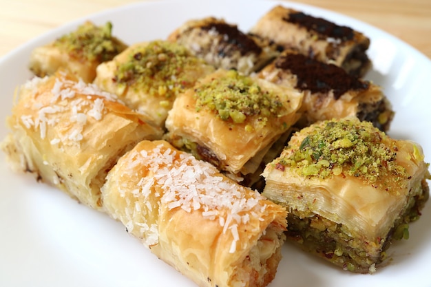 Different types of mouthwatering Baklava pastries served on white plate