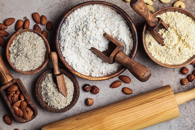 Foto diversi tipi di farina di noci, mandorle, nocciole e anacardi sfondo scuro dieta chetogenica e concetto senza glutine