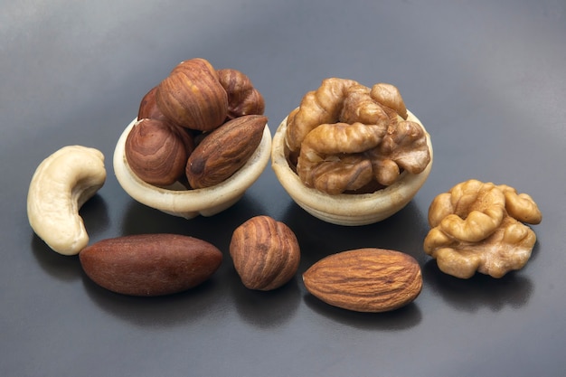 Different types of nuts in a waffle cone on a gray table. Healthy and protein food